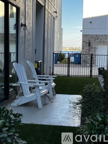 Two white chairs are placed on a patio.