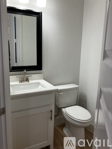 A white toilet sits next to a sink in a small bathroom.