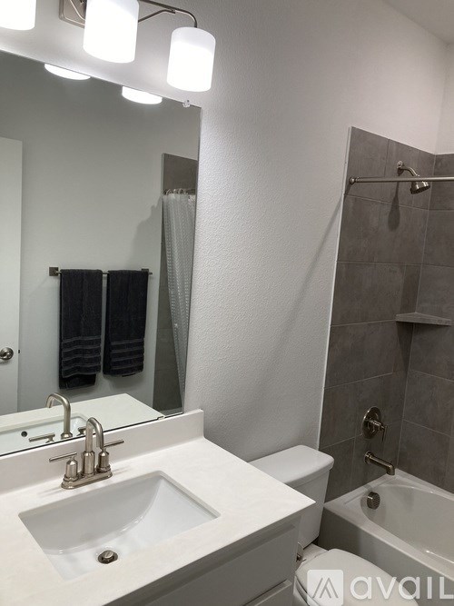 A bathroom with a white sink and a bathtub.