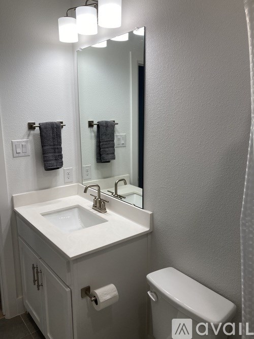 A bathroom with a white sink and toilet.