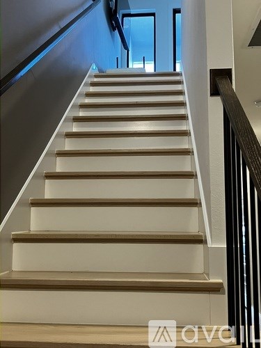 A set of stairs with a black railing.