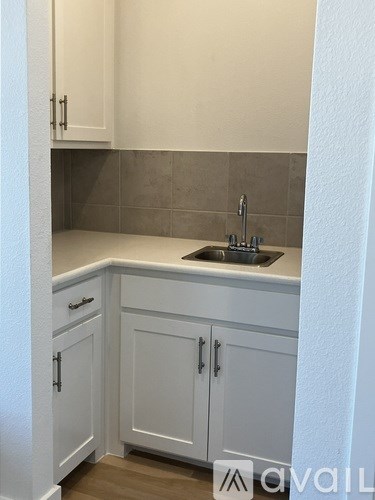 A kitchen with white cabinets and a sink.