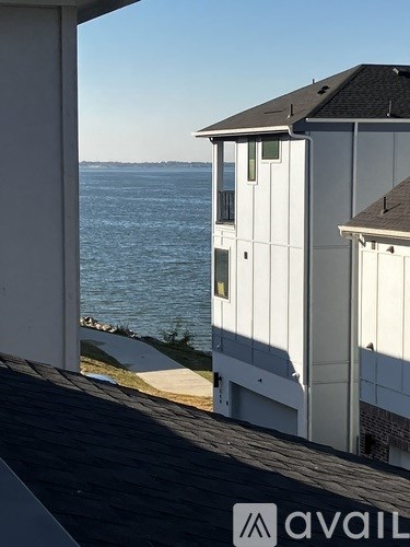 A white building with a balcony overlooking the water.