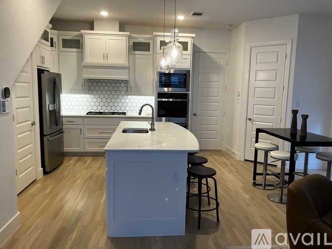 A kitchen with a white island and stools.