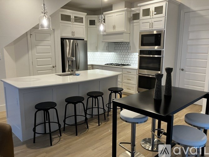 A kitchen with a bar area and a black table.
