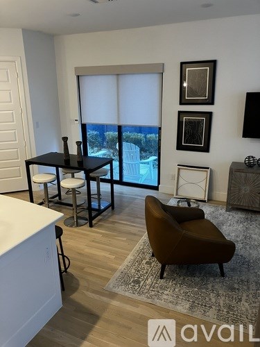 A living room with a brown chair and a white cabinet.