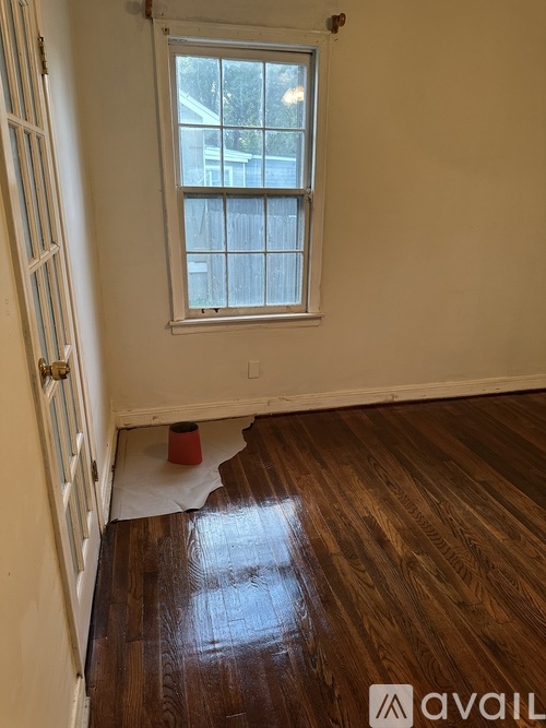 A room with a window and wooden floors.