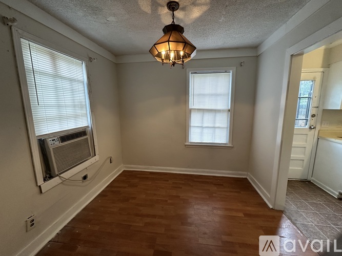 A room with a wooden floor and a white wall.