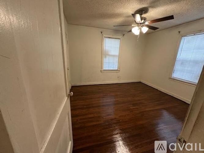 A room with wooden floors and a ceiling fan.