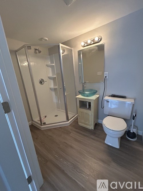 A bathroom with a toilet, sink, and shower.