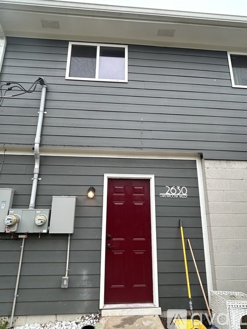 A house with a red door and a grey siding.