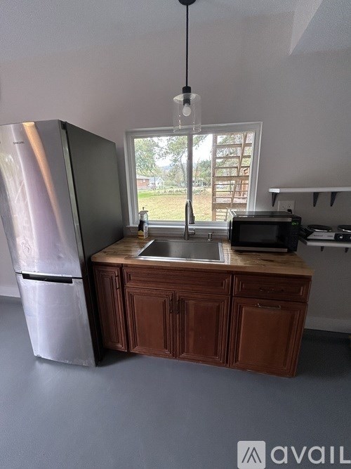 A kitchen with a sink and a fridge.