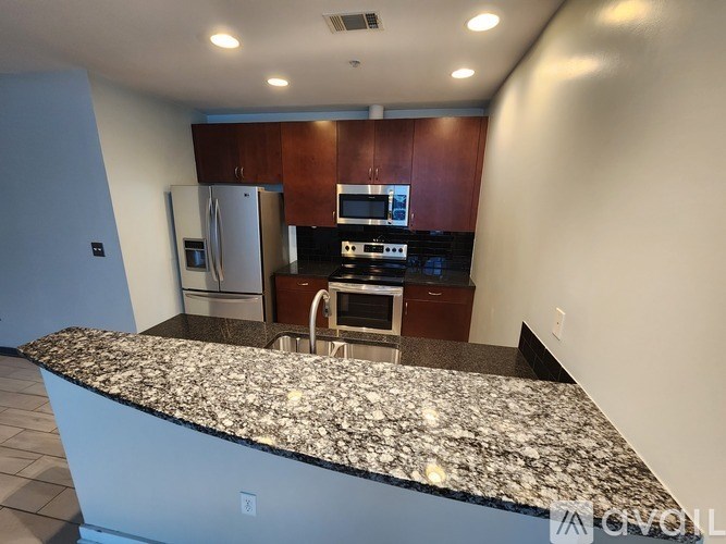 A kitchen with granite countertops and stainless steel appliances.