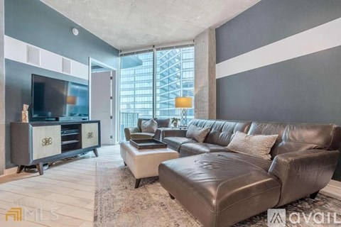 A living room with a brown leather couch and a television.