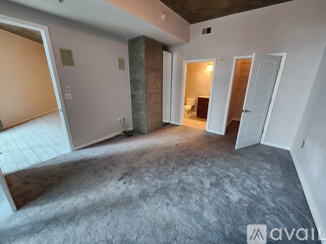 A room with a carpeted floor and a pillar in the middle.