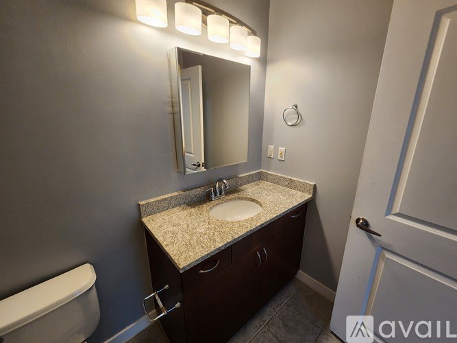 A bathroom with a sink, mirror, and toilet.