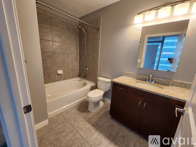 A bathroom with a tub, toilet, and sink.