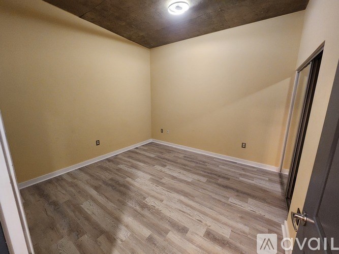 A room with wooden flooring and a ceiling light fixture.