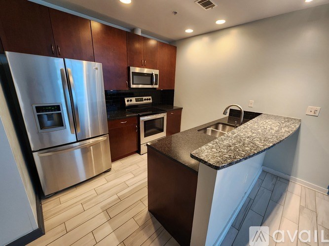 A kitchen with a granite countertop and stainless steel appliances.
