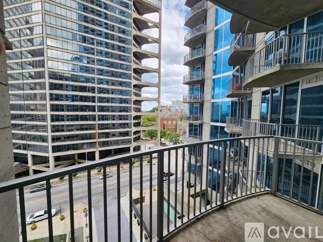 A balcony overlooks a city street with cars and buildings.