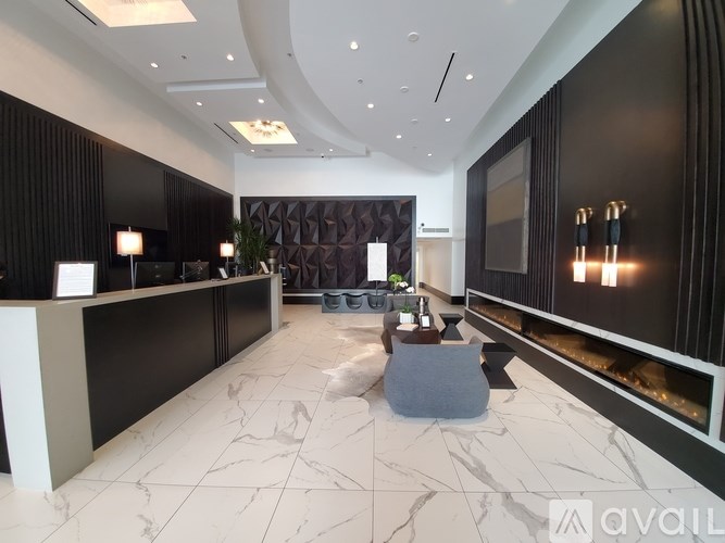 A reception area with a white marble floor and a black reception desk.