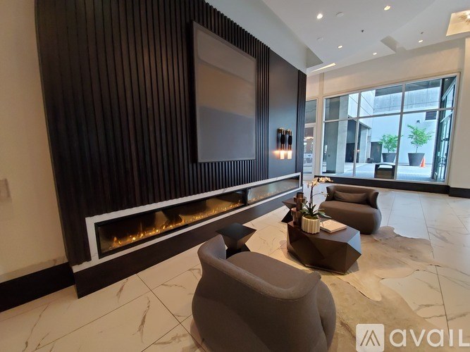 A modern living room with a fireplace and grey armchairs.