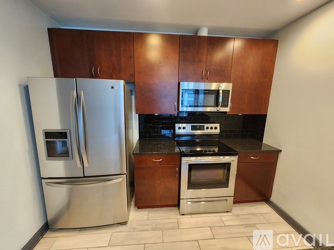 A kitchen with a stainless steel refrigerator and an oven with a microwave above it.