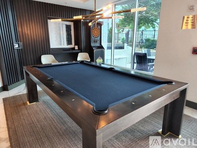 A pool table in a room with a window overlooking a patio.