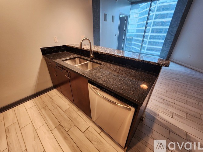 A kitchen with a black granite countertop and a white dishwasher.
