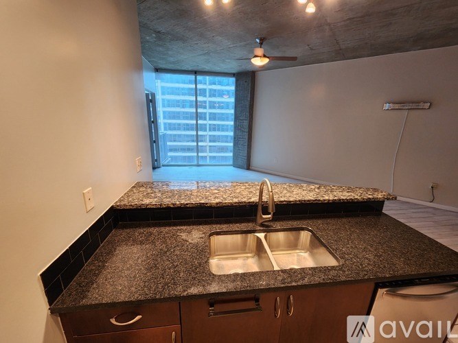 A kitchen with granite countertops and a window overlooking a cityscape.