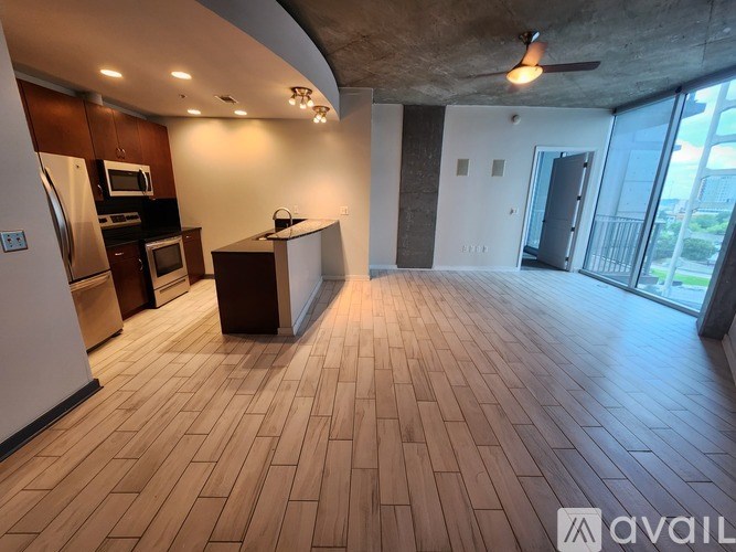 A spacious kitchen and living room with wooden flooring and modern appliances.
