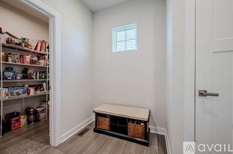 A pantry with a window and a bench.