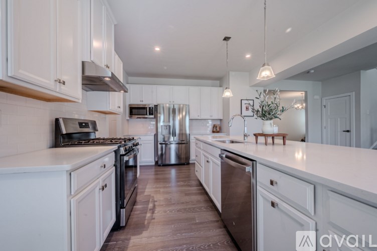A modern kitchen with white cabinets and stainless steel appliances.