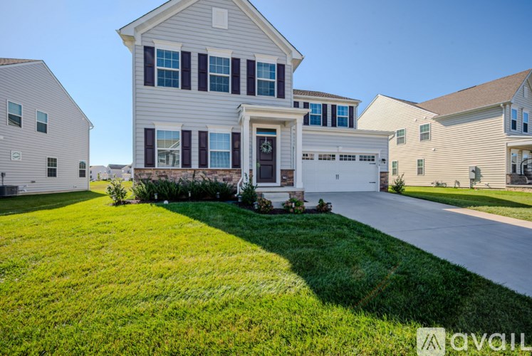 A house with a garage and a driveway in front of it.