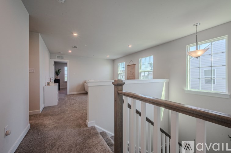 A spacious room with a carpeted floor and a window with blinds.