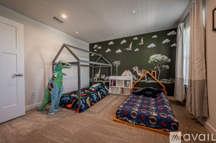A room with two beds and a dinosaur toy.