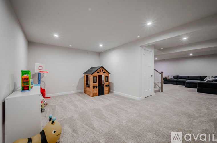 A child's play area with a toy kitchen set and a wooden dollhouse.