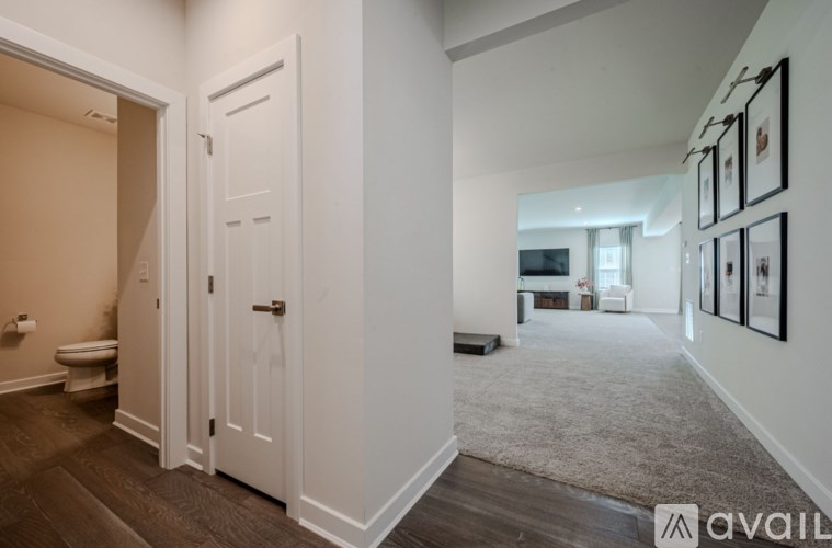 A hallway with a carpeted floor and a white door.