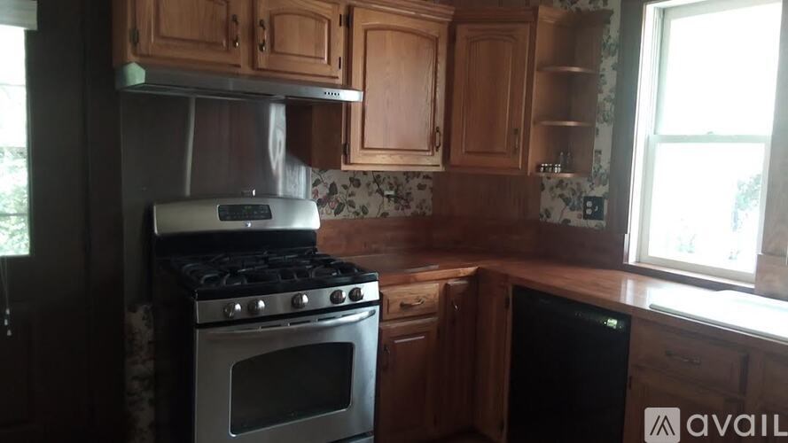 A kitchen with wooden cabinets and a stove top oven.