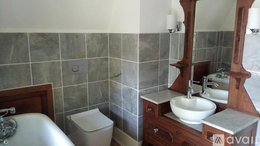 A bathroom with a toilet, sink, and mirror.