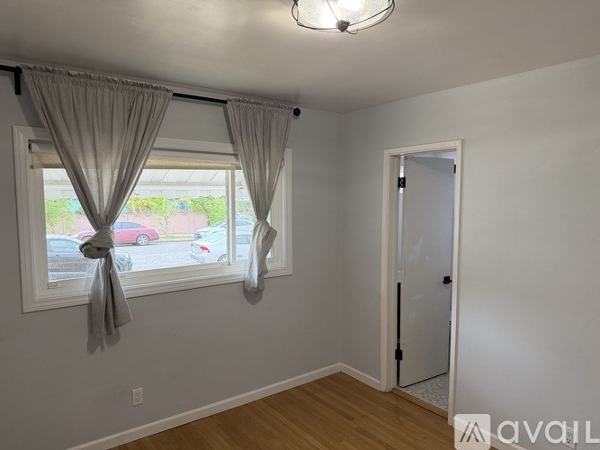 A room with a window and a door is available for rent.