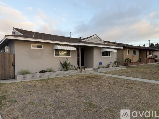 A house with a brown roof and a white garage door is available for rent.