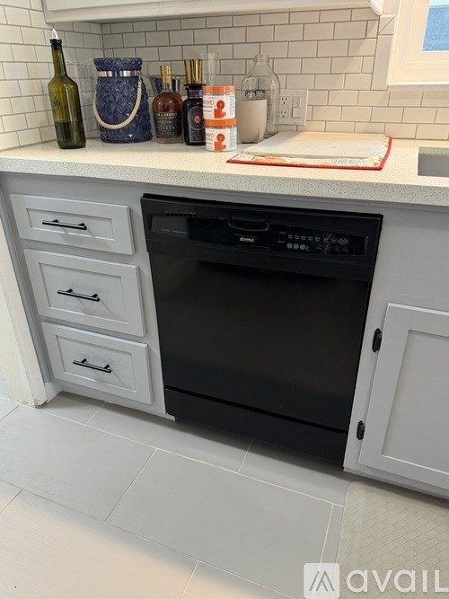 A kitchen with a black oven and white cabinets.