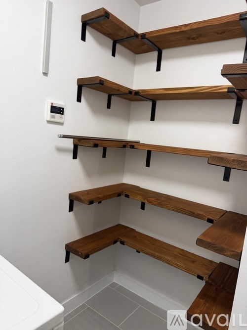 A white wall with a row of shelves on it.