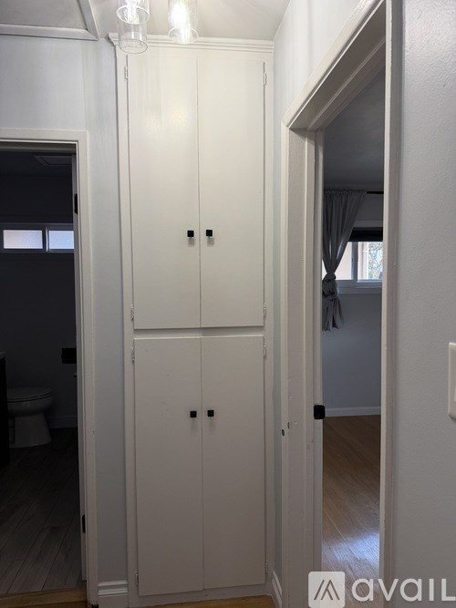 A white wardrobe with two doors and two drawers is in a room.