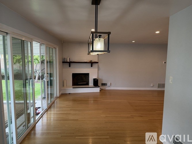 A large, empty room with a fireplace and a chandelier.
