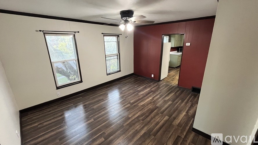 A room with wooden flooring and a ceiling fan.