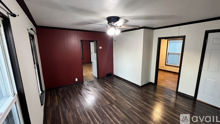 A room with wooden floors and a ceiling fan.