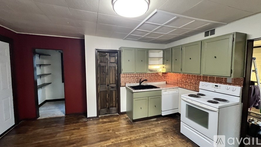 A kitchen with a white stove top oven and a white microwave.