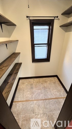 A small room with a window and a tiled floor.